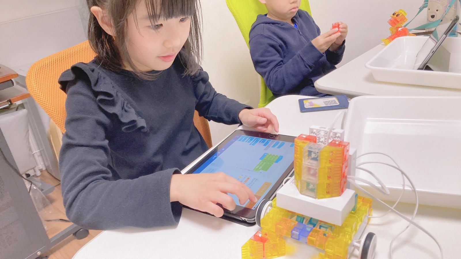 タブレットでプログラムを操作しながら、KOOVの作品に取り組む子ども
