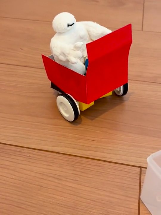 紙粘土でつくったベイマックスを乗せた赤い車が、向きを変えながら走る様子