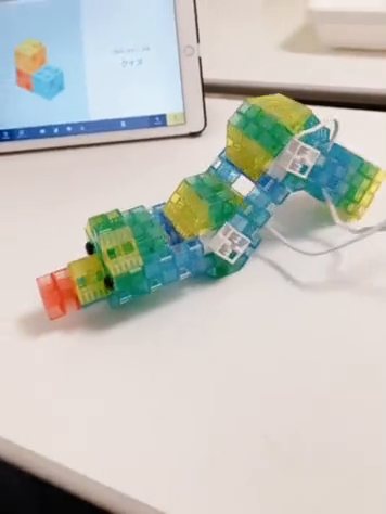 ブロックをつないでつくった青虫の作品が、サーボモーターで体の角度を変えながら前進する様子