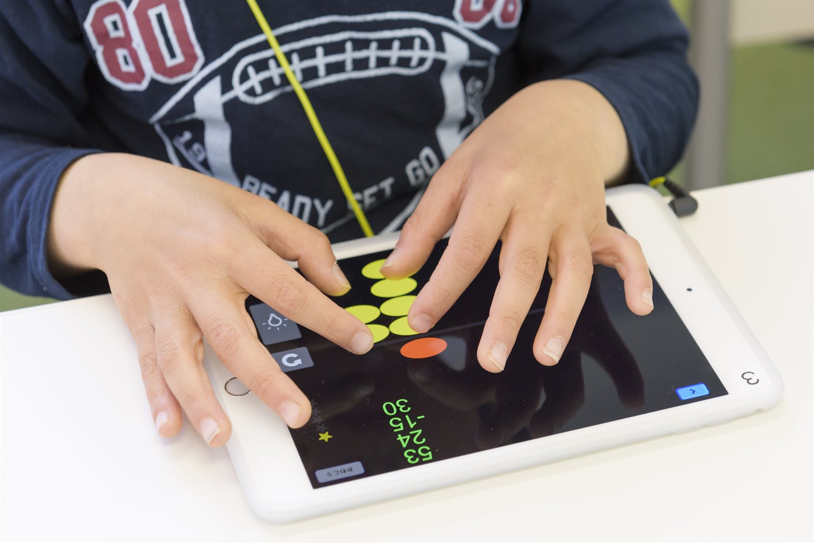 タブレットに表示された珠を両手で操作する、そろタッチの手元
