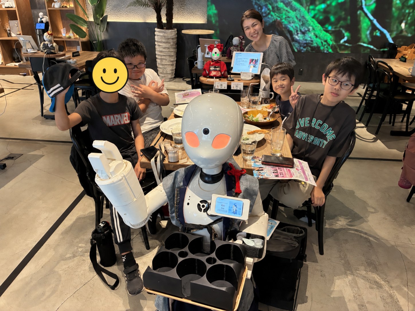 見学先で、ロボットを囲んで笑顔を見せる子どもたち